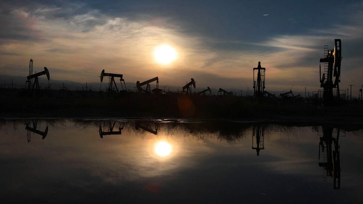 Oil pumps and equipment reflect on water pooled after recent storm in the South Belridge oil field in Kern County, Calif., on March 4, 2014. (Brian van der Brug/Los Angeles Times/TNS)