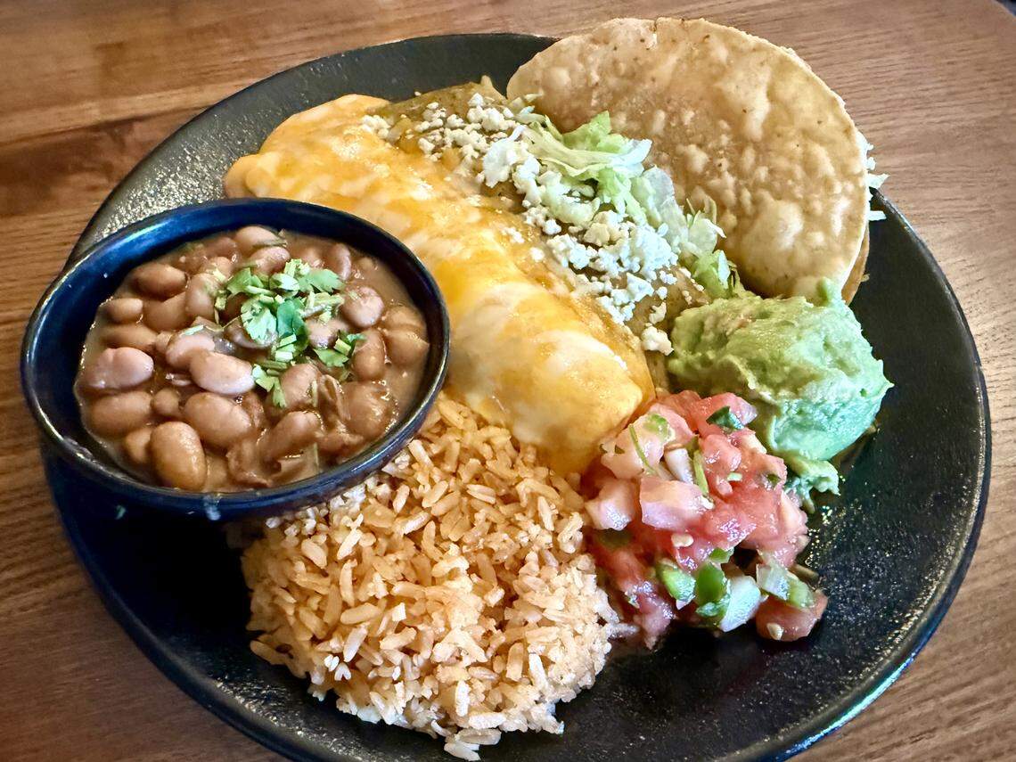 A combination plate at Uncle Julio’s: a chipotle queso enchilada, a green chicken enchilada, a beef taco and rice and beans, as seen Nov. 30, 2025.