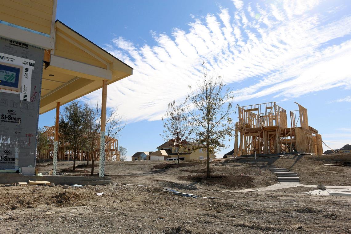 Construction crews work on homes under development at the Walsh Ranch in Fort Worth.