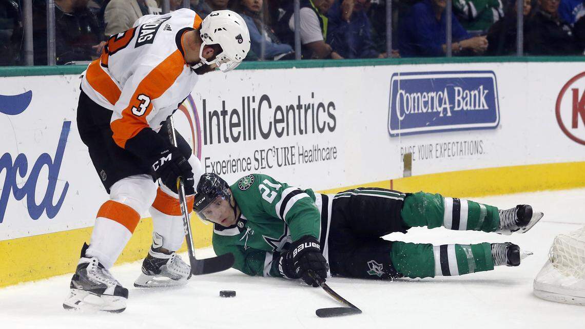 Philadelphia defenseman Radko Gudas, left, and  Stars left wing Antoine Roussel fight for control of the puck during the first period of Tuesday's game in Dallas.