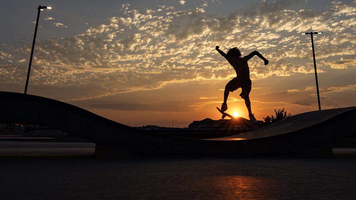 Ramsey Rivera skates up a slope at sunset at Chisholm Trail Skate Park in Fort Worth on Tuesday, Aug. 29, 2023.