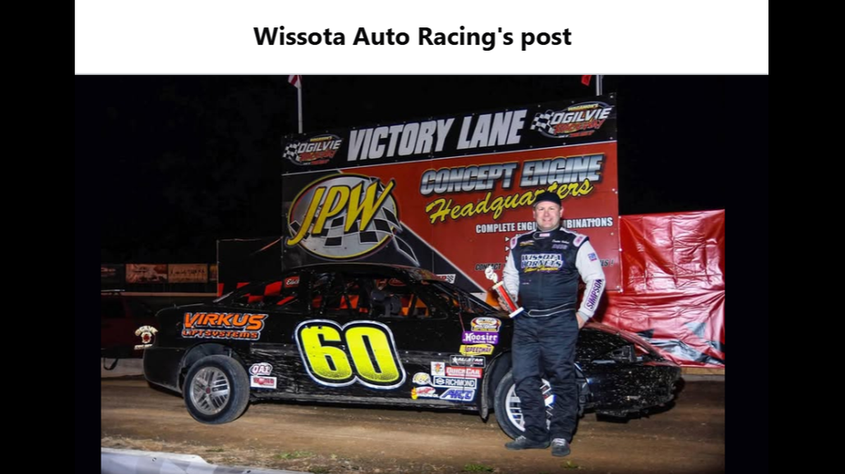 Dustin Virkus posing next to a race car.
