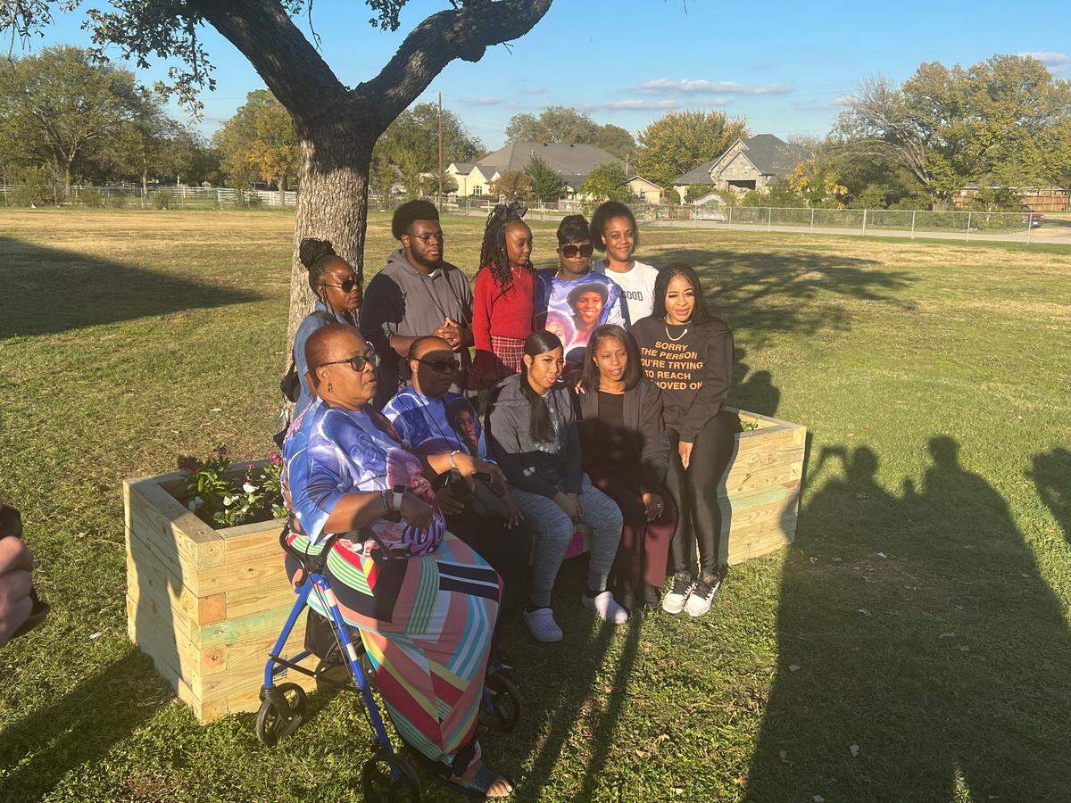 Family members of Yolanda Gibbs, a cafeteria worker at David K. Sellars Elementary School who was shot and killed outside of the school on Oct. 11, 2023, pose on a bench on Tuesday, Nov. 14, that was built and dedicated to Gibbs alongside a new playground.