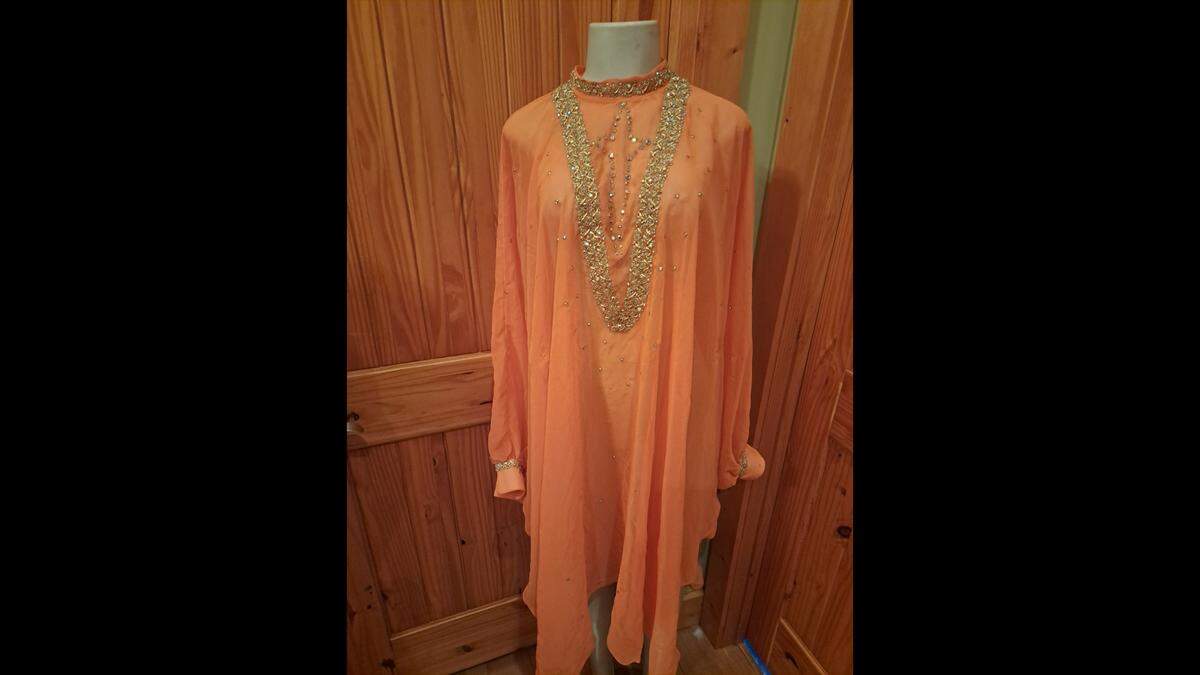 Patric Parkey, a Dolly Parton memorabilia collector in Pigeon Forge, Tenn., recently purchased at a Nashville auction this orange cape once worn by Parton. Parkey discovered through a Star-Telegram story Dec. 18 that the cape was from Parton’s Fort Worth concert on Dec. 2, 1977, at Panther Hall.