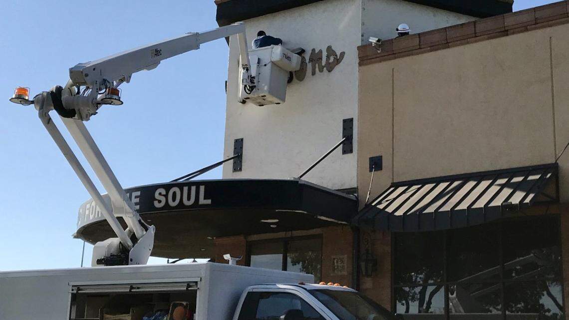 Workers remove the sign from the former Buttons location in Fort Worth.