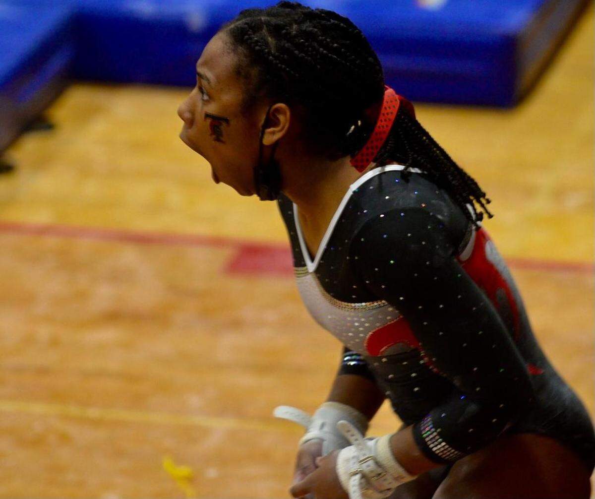 Sophomore Jihra Hill of Euless Trinity reacts after scoring a 9.92 to win the Texas High School State title on the uneven bars.