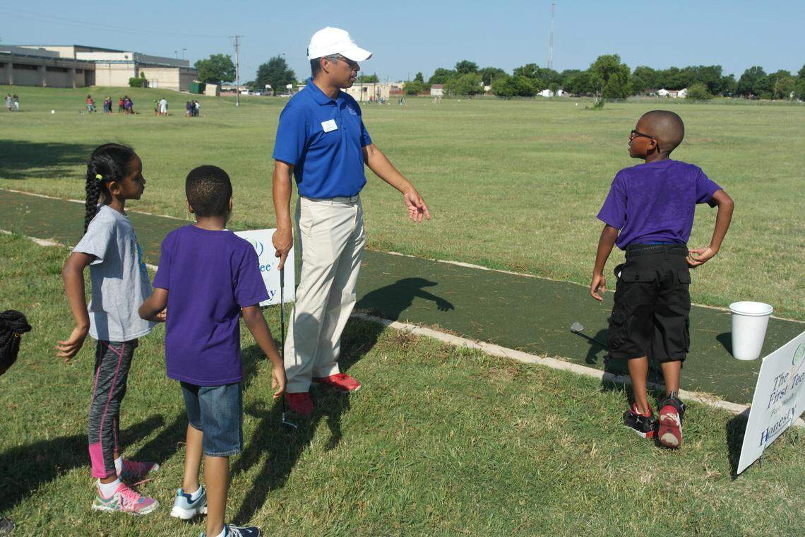 Briscoe Learning Center Site Coordinator Jason Rocha works with The First Tee of Fort Worth participants on their driving.