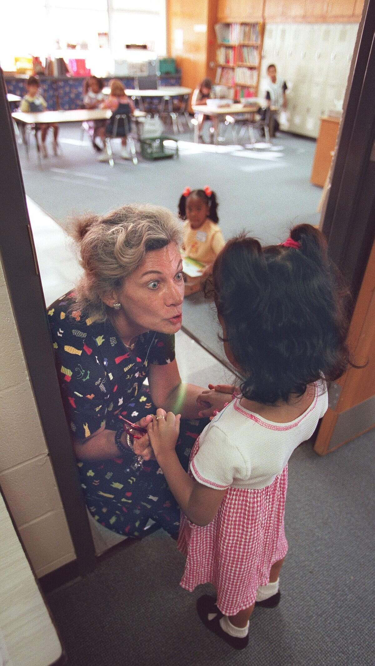 Aug. 12, 1999: Meeting her new pupil, teacher Nancy Daniels talks to kindergartner Perla Lujan on the first day of school for Arlington public schools. Roark welcomed about 600 students to school, along with a lot of parents.