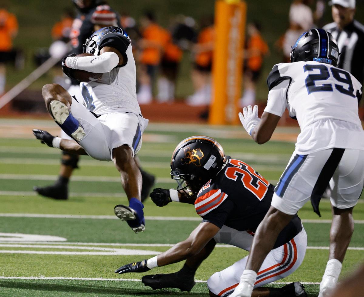 North Crowley defender Draden Fullbright (4) is tripped up by Rockwall running back AJ Hatcher (22) after intercepting a pass during a UIL 6A Conference football game at Wilkerson-Sanders Memorial Stadium in Rockwall Texas, Thursday, Sept. 19, 2024.