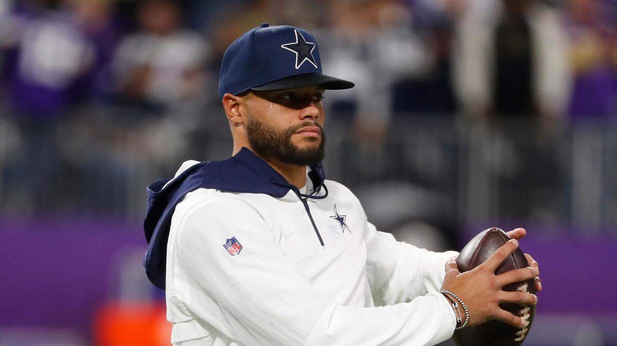 Injured Dallas Cowboys quarterback Dak Prescott stands on the field before an NFL football game against the Minnesota Vikings, Sunday, Oct. 31, 2021, in Minneapolis.