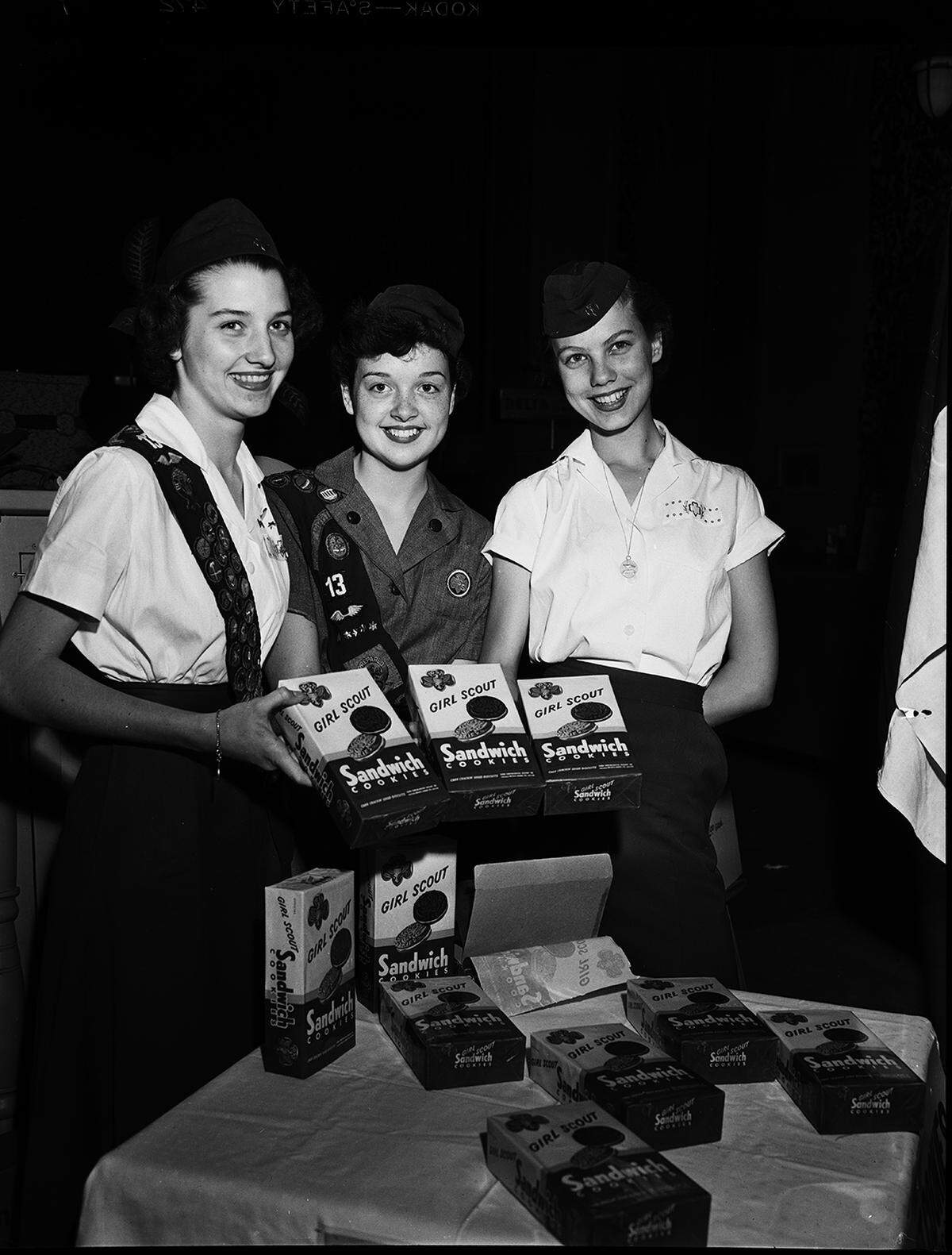 March 30, 1953: These three members of Girl Scout Troop 13 are finding that Fort Worth residents are “more than glad” to buy cookies packaged especially for their organization. Helping to raise money for Camp Timberlake, Girl Scout camp at Eagle Mountain Lake, are left to right, Frances Barclay, Scotty Owen, and Shirley Farmer.