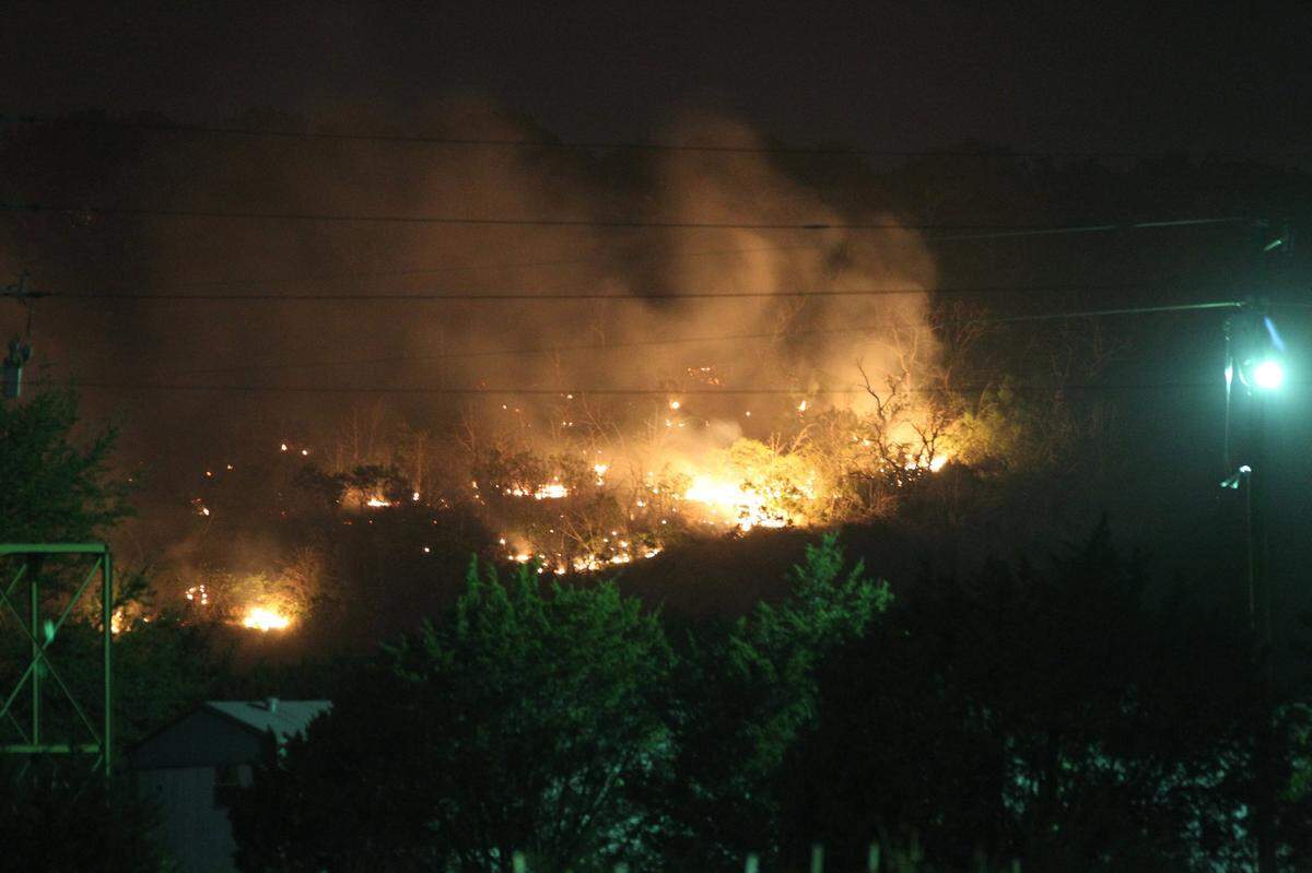 A hillside near the intersection of US 180 and Highway 16 in Strawn is on fire at on April 15, 2011. Grass fires and strong winds burnt many homes and acreage west of Fort Worth near Graham, Texas in the Possum Kingdom Lake area.