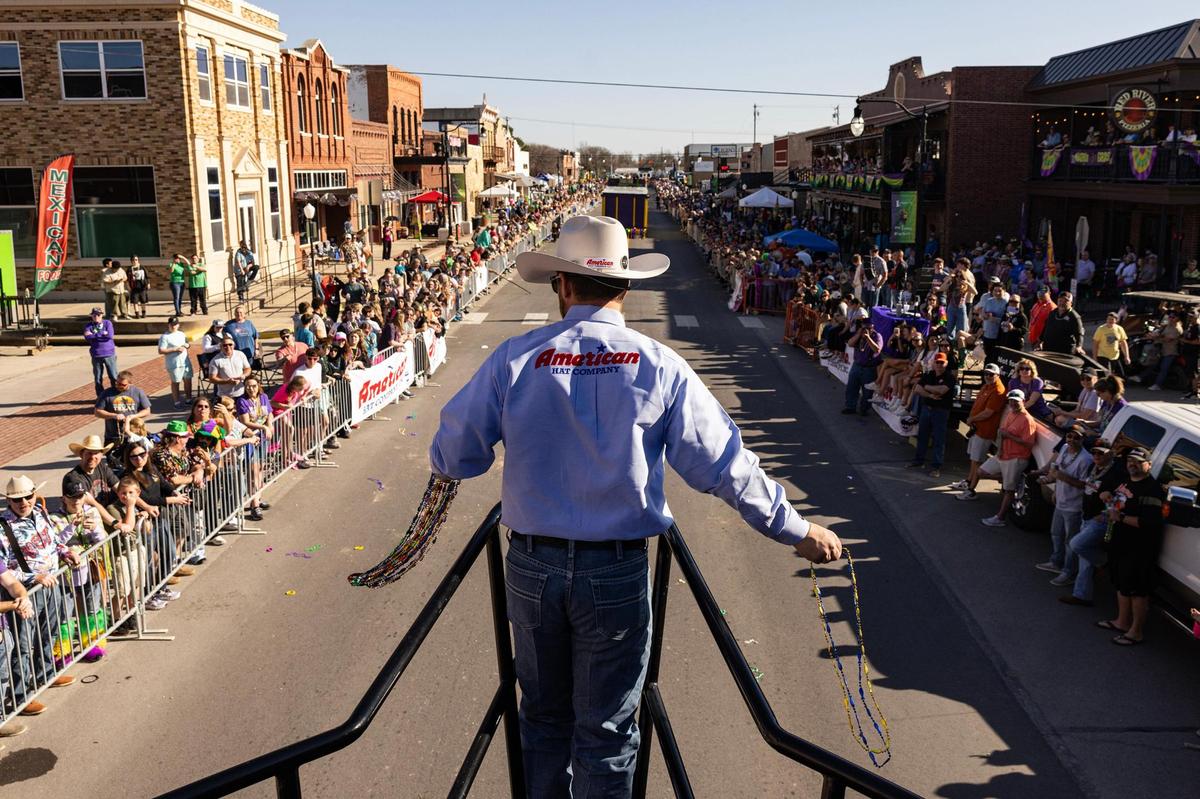 Cody Bates, the Vice President of Operations for the American Hat Company, tosses beaded necklaces from the front of the pirate-ship themed parade float for the 15th Annual Mardi Gras Nocona Style on Clay Street in Nocona on Saturday, Mar. 1, 2025.