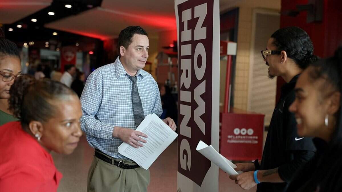 Mitch Graham (center) inquires about jobs at Triton Recovery during a job fair in April in Sunrise, Florida. 