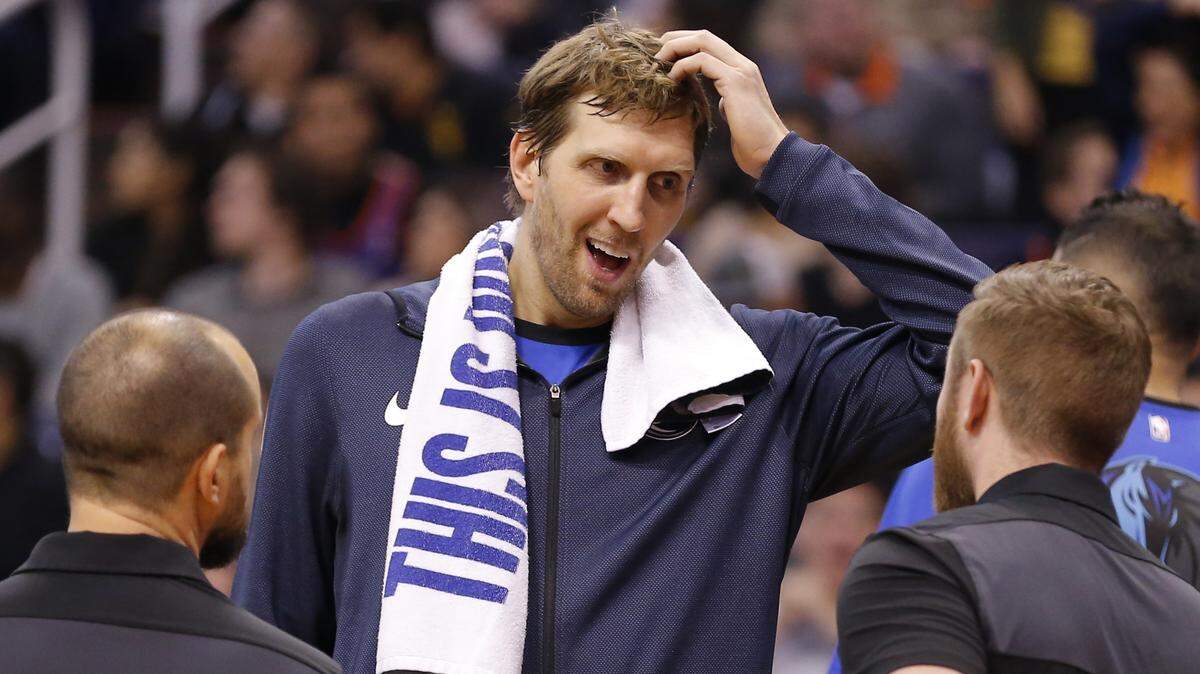 Dallas Mavericks forward Dirk Nowitzki, center, made his season debut Thursday night in Phoenix as he has now played in 21 seasons with the same team, an NBA record.