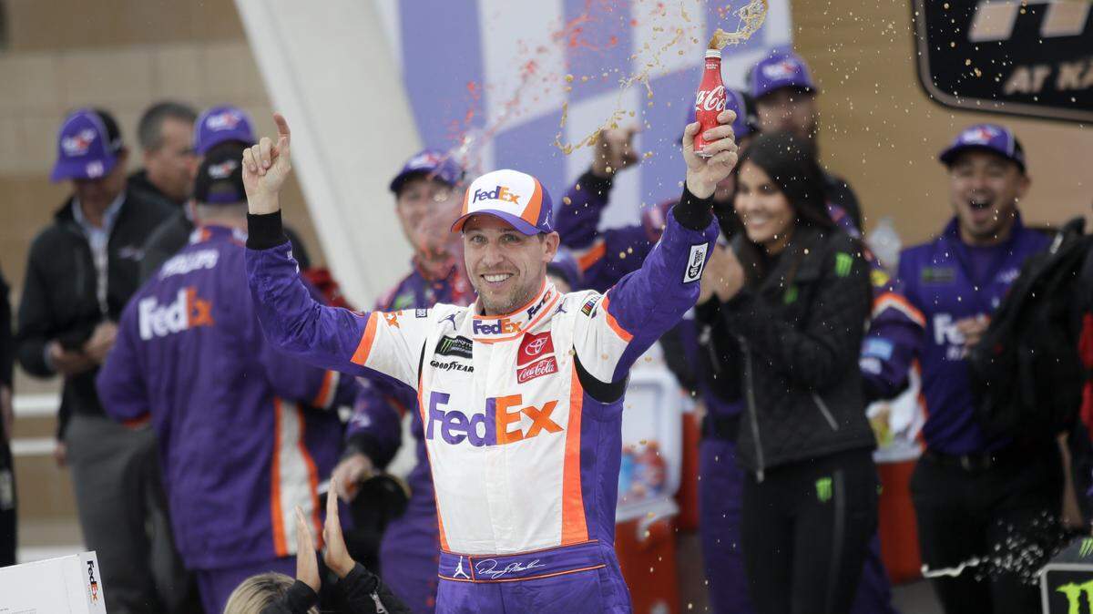 Denny Hamlin celebrates after winning a NASCAR Cup Series auto race at Kansas Speedway in Kansas City, Kansas, Sunday, Oct. 20, 2019.
