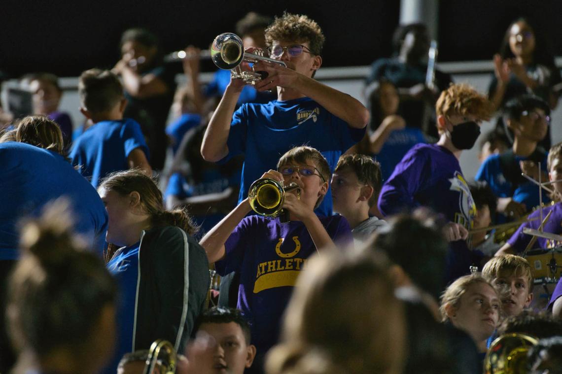 Members of the Boswell High School Band of Gold in the stands during a football game.