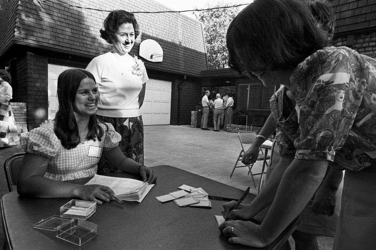 Sept. 10, 1975: Mrs. Andrew Armstrong, standing right, president of UTA Faculty Women’s Club, and Mrs. Kenneth Roemer, president-elect of the club, supervise the sign-in for name tags. More than 250 guests attended the supper at the University of Texas at Arlington.
