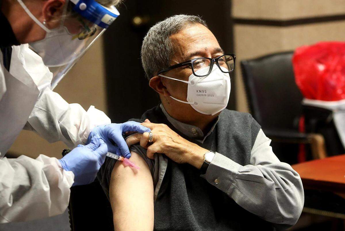 In this December 2020 file photo, Tarrant County Public Health medical director Dr. Catherine Colquitt, left, administers a COVID-19 vaccine to Tarrant County Commissioner Roy Brooks. In 2021, when the UNT Health Science Center ended its vaccination work in the county, Brooks was publicly critical of the amount of work the center accomplished.