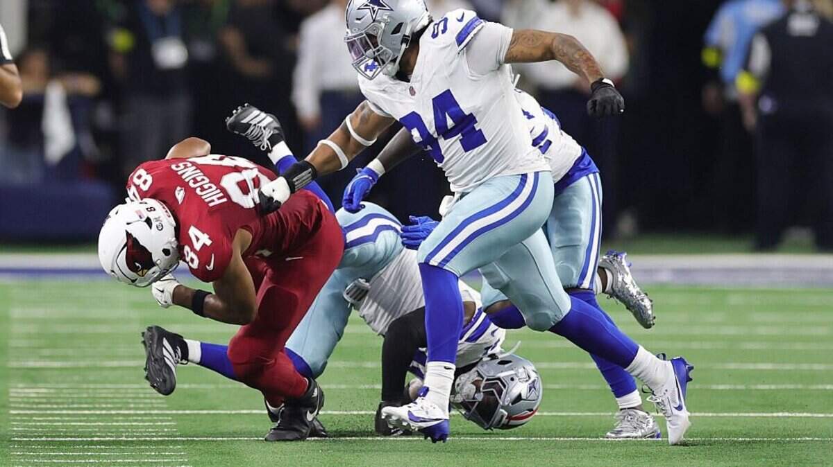 Elijah Higgins of the Arizona Cardinals rushes ahead of Marshawn Kneeland of the Dallas Cowboys during the second quarter in the game at AT&T Stadium on Monday.