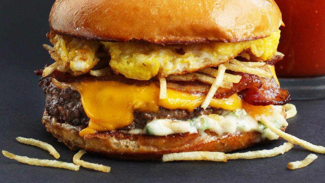 The new Hopdoddy “breakfast” cheeseburger has a beef-sausage-ham patty with bacon added.