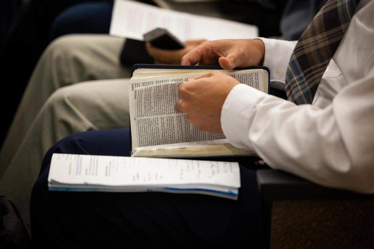 Jonathan Shelley of Stedfast Baptist Church thumbs through a Bible during public comment of the City Council meeting Monday in Watauga.