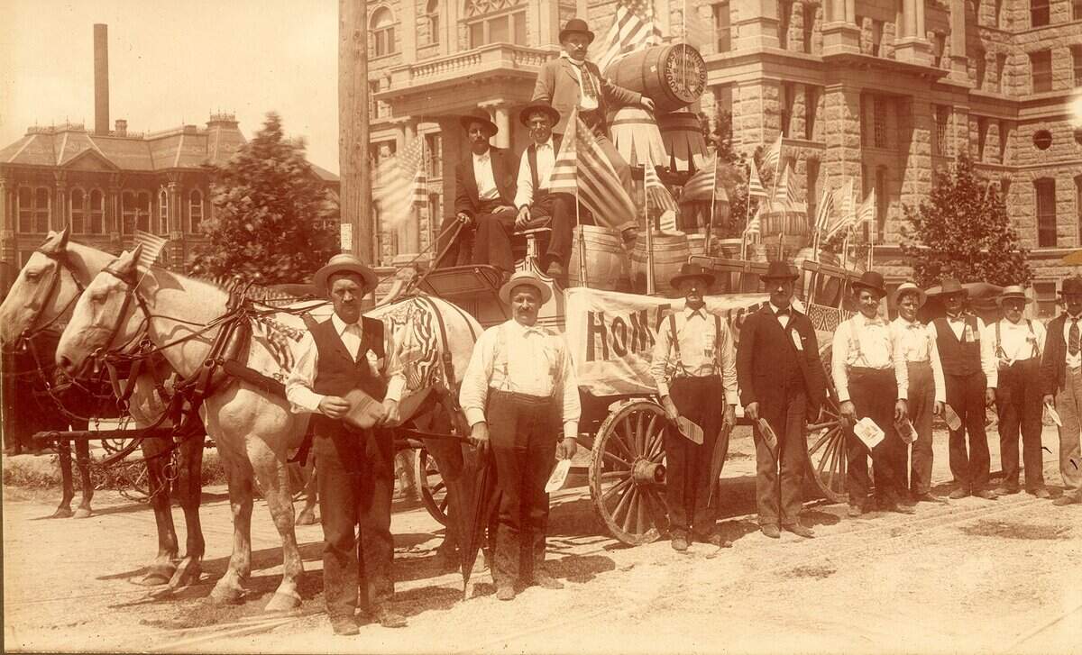 Circa 1899-1902: Labor Day parade in front of Tarrant County Courthouse. Cooper Co.’s float drawn by horse and buggy; Edwin Perry Barclay on float.
