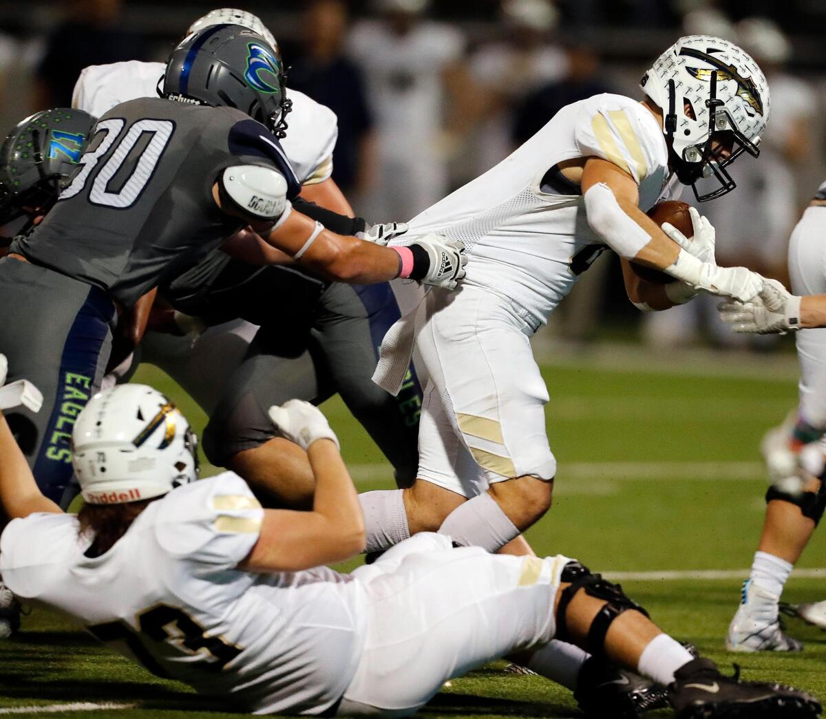 Keller running back Austin Coleman (8) is drug down by Eaton linebacker Andrew Perkins (30) in the middle of the pack in a high school district 4-6A football game at NWISD Stadium in Justin, Texas, Friday Oct. 08, 2021. Keller led Eaton 21-10 at the half. (Special to the Star-Telegram Bob Booth)