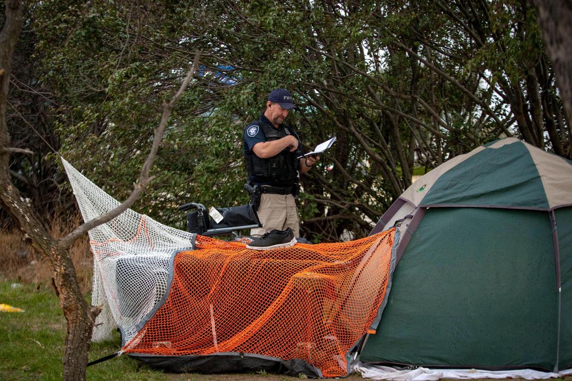 Officer Mike Kuzenka speaks with a person who set up a tent set up on private property on Jan. 18 in Fort Worth. Kuzenka, an officer of the Homeless Outreach Program and Enforcement (HOPE) Team, investigates after a parent at a nearby school saw the tent and submitted a complaint through the MyFortWorth app.