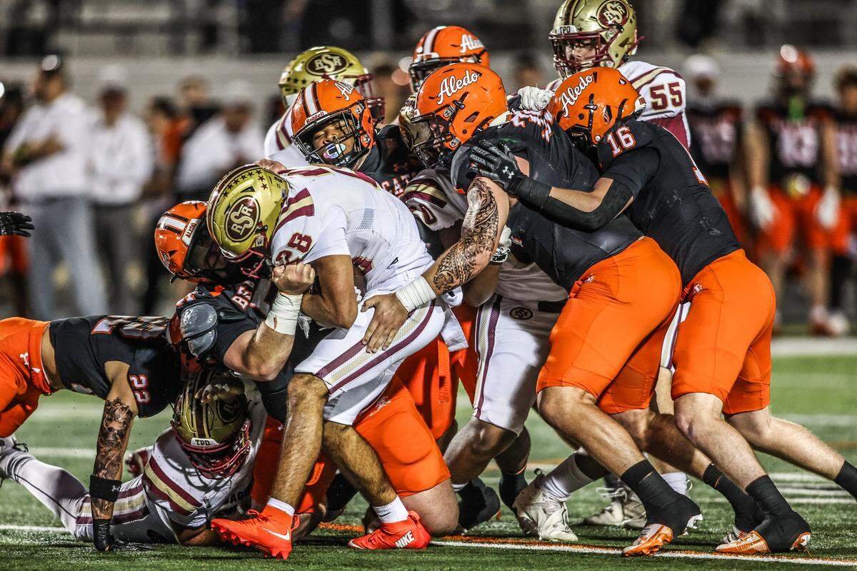 The Aledo defense stops Saginaw running back Isiah Quinones (28) for no gain in a Class 5A Division I bi-district playoff game on Thursday, November 13, 2025 at Tim Buchanan Stadium in Aledo, Texas.