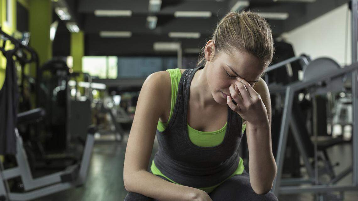 Young woman appears stressed out after working out in a health club.