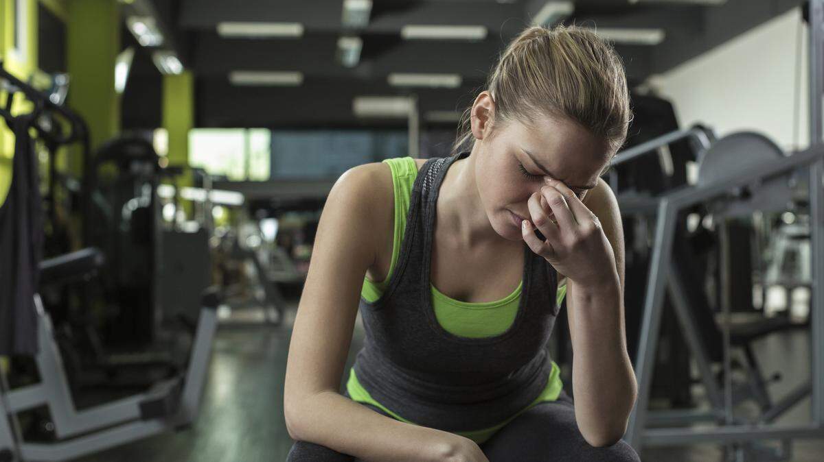 Young woman appears stressed out after working out in a health club.