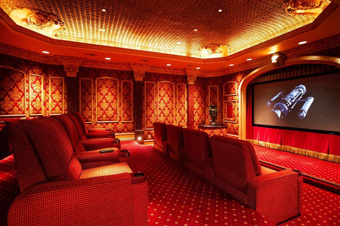 A lavish home theater with plush red chairs