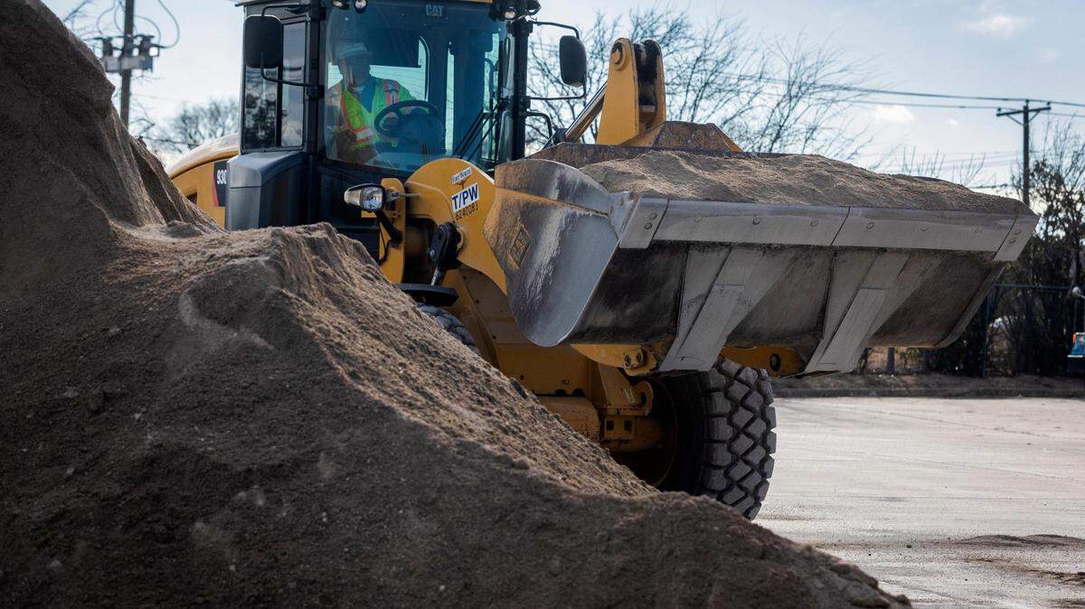 A tractor loads sand to sift as the city prepares for a winter storm Monday, Jan. 31, 2022, in Fort Worth.