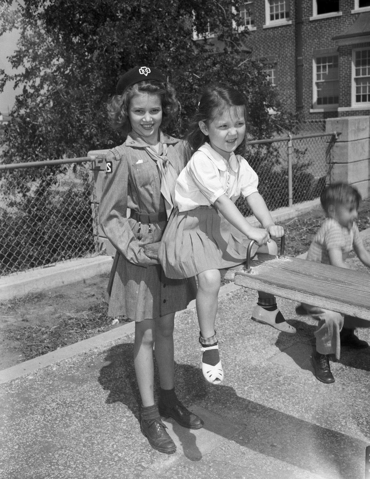 April 26, 1944: Girl Scouts at nursery school. Wanda Faye Balch, 11, gives balance to the enthusiastic see-sawing of Patricia Fay Rowland.