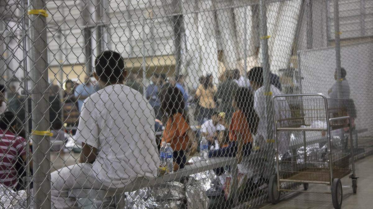 In this photo provided by U.S. Customs and Border Protection, people who've been taken into custody related to cases of illegal entry into the United States sit in one of the cages at a facility in McAllen, Texas, Sunday, June 17, 2018.