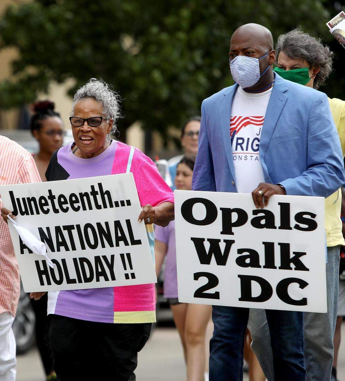Opal Lee carries a sign calling for Juneteenth to become a national holiday as she and others walk Lancaster Avenue to celebrate Juneteenth on June 19, 2020, in Fort Worth. Lee was followed by a convoy of hundreds of cars, some decorated, as she made her way to Will Rogers Coliseum.