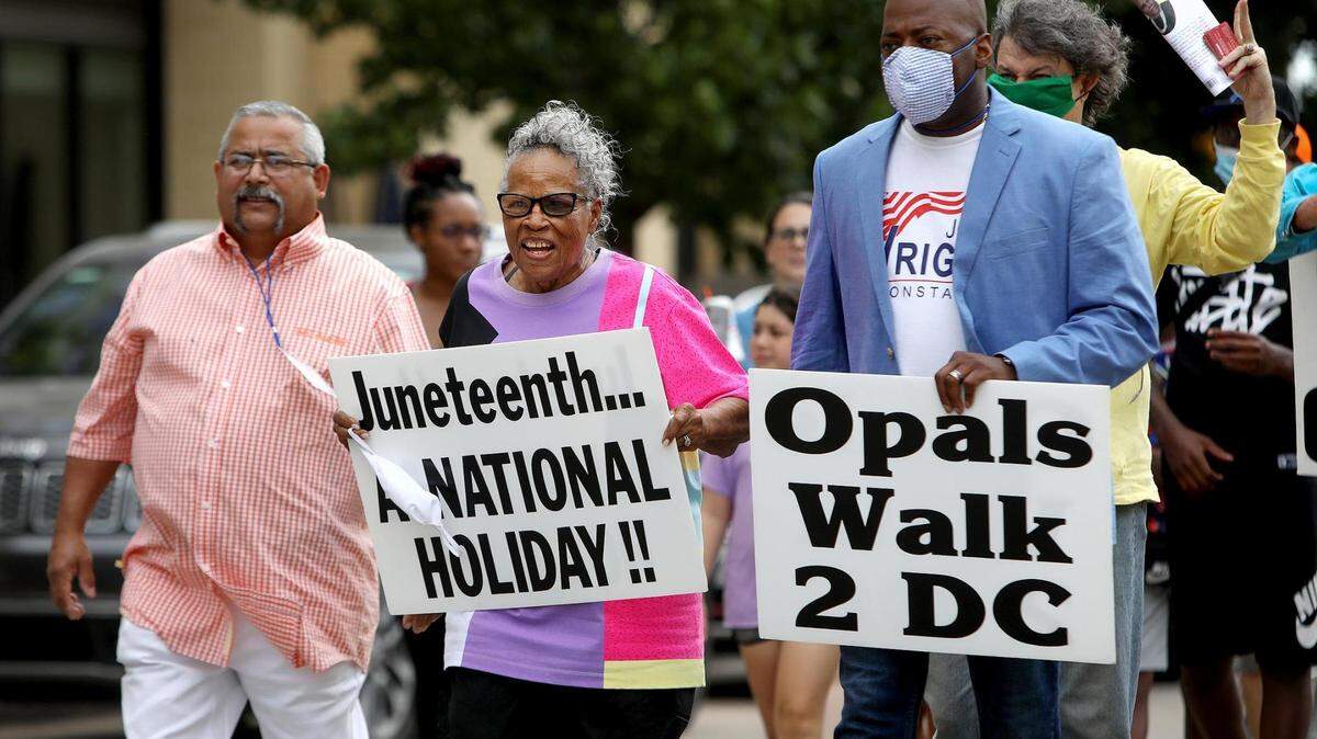 Opal Lee carries a sign calling for Juneteenth to become a national holiday as she and others walk Lancaster Avenue to celebrate Juneteenth on June 19, 2020, in Fort Worth. Lee was followed by a convoy of hundreds of cars, some decorated, as she made her way to Will Rogers Coliseum.