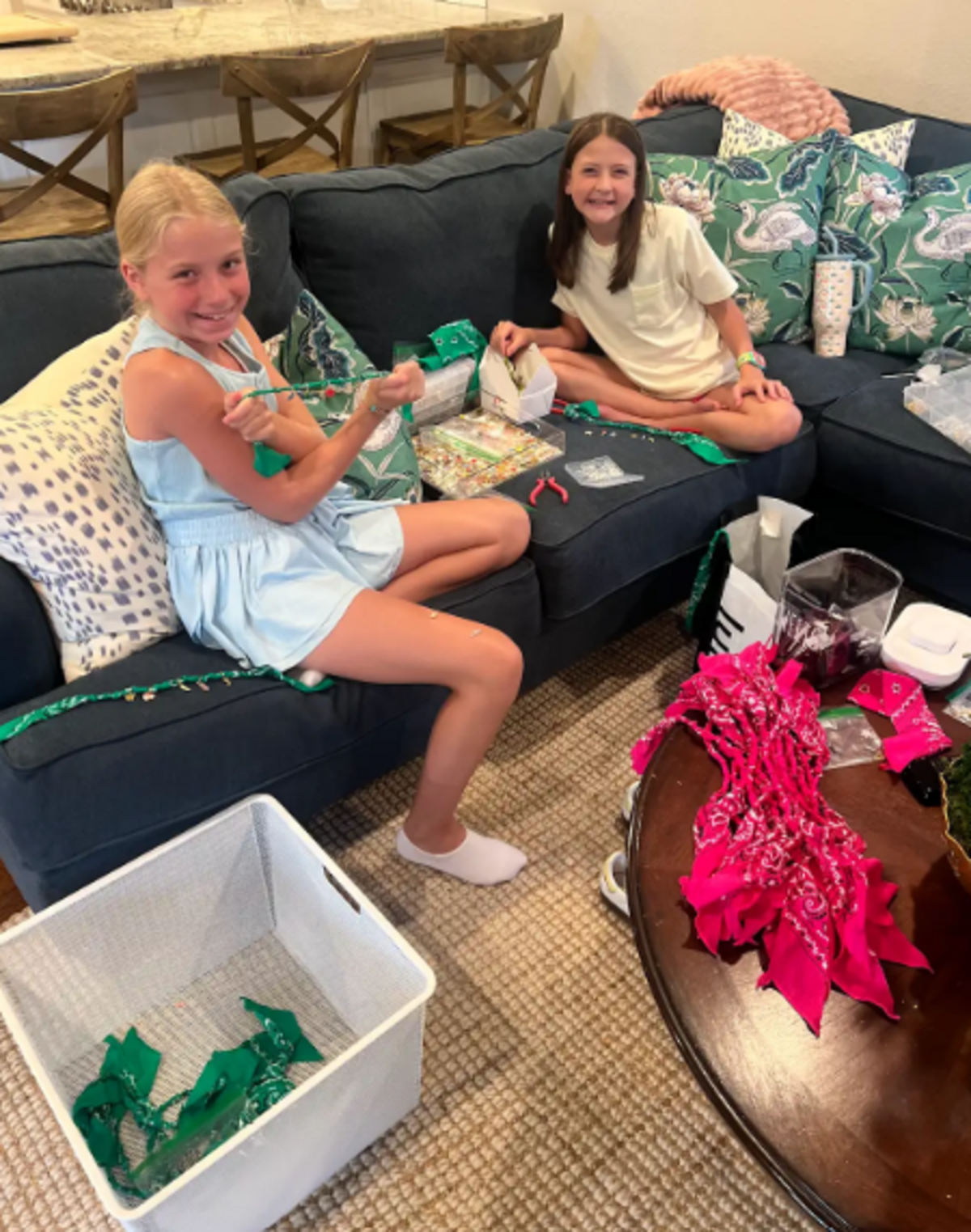 Piper Twist, 11, and Allie Grace Anderson, 12, are shown making bandanna necklaces to raise funds for Camp Mystic and Central Texas flood relief.