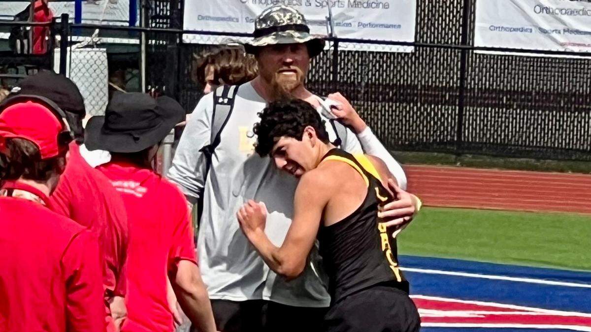 Grant Martinez of Frisco Legacy Christian Academy gets a hug from his coach, Barrett Hardage, after running more than two laps of the 1600-meter run with only one shoe at TAPPS Class 5A state track meet. Martinez managed to finish fourth.