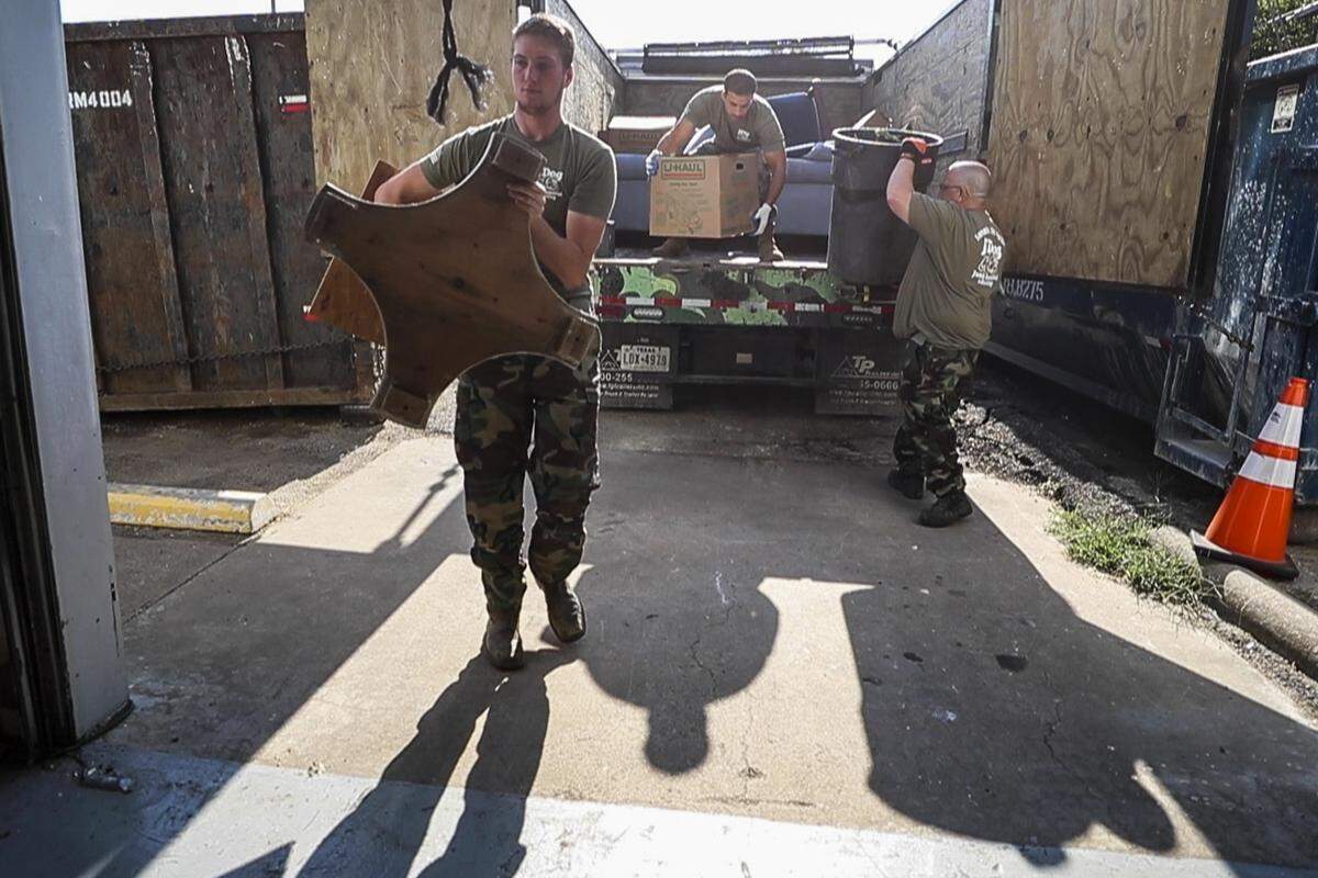 Veterans unload furnishings from the truck to the warehouse Wednesday, Aug. 7, 2019, at JDog Junk Removal and Hauling.