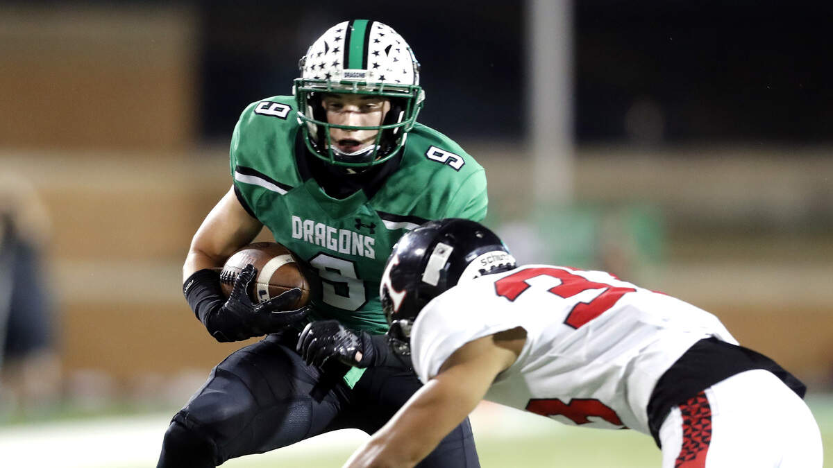 Southlake wide receiver Carson White (9) attempts to avoid the tackle of Trinity defensive back Soti Leota (33) in the first half of a high school 6A Division I Regional Round football playoff game at Apogee Stadium in Denton, Texas, Friday, Nov. 30, 2018. Carroll led 21-7 at the half. (Star-Telegram Bob Booth)