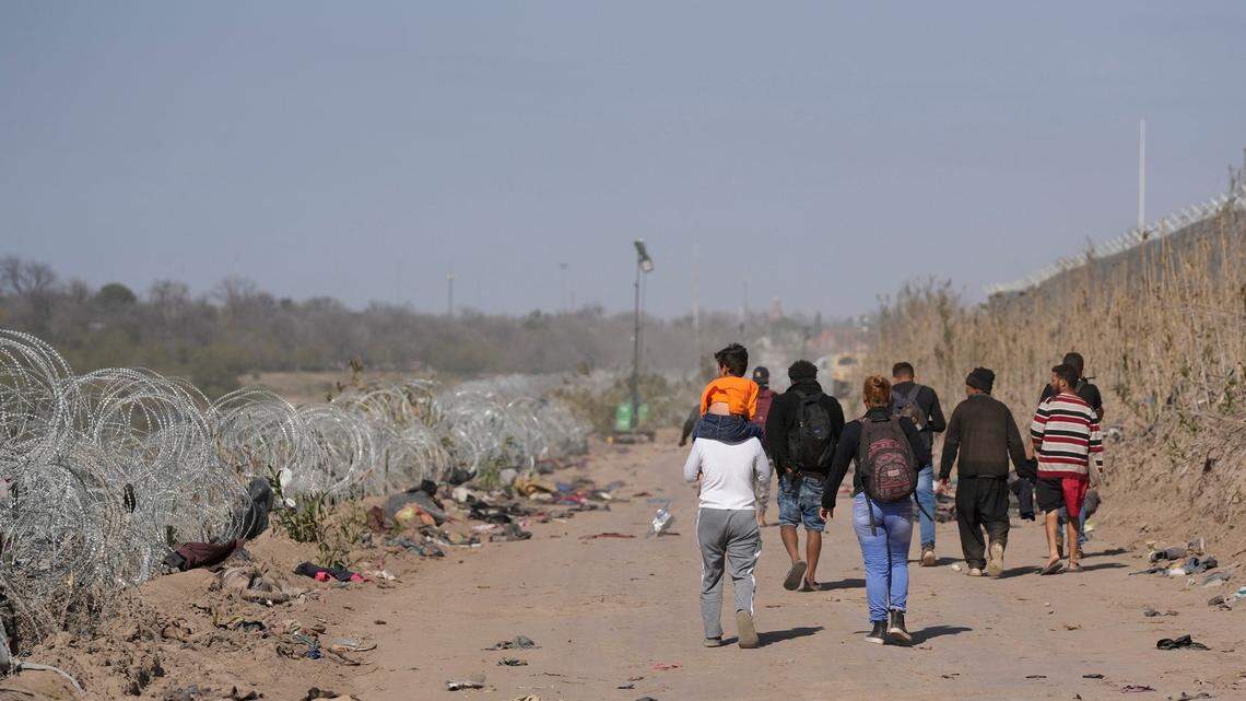 A group of migrants from Venezuela walk along the banks of the Rio Grande to surrender to U.S. Border Patrol after they entered Texas at Eagle Pass on Monday January 8, 2024.