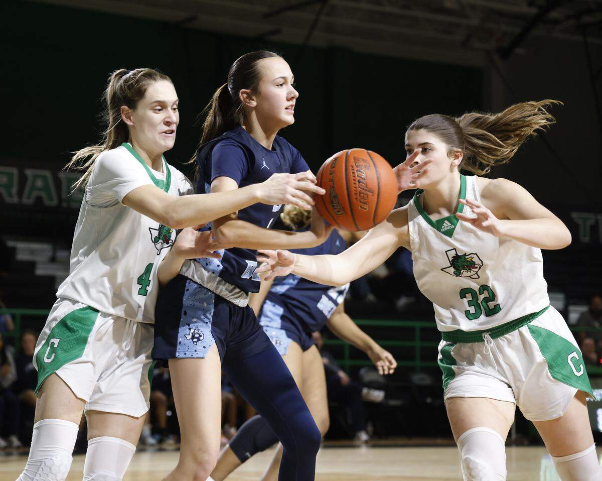 Southlake guard Mattie Renda (4) reaches in on L.D. Bell guard Reagan Bennett (11) aided by forward Jillian Hall (32) during the second half of a UIL girls basketball game between L.D. Bell and Southlake Carroll at Southlake Senior High School in Southlake, Texas, Tuesday Feb. 03, 2026
