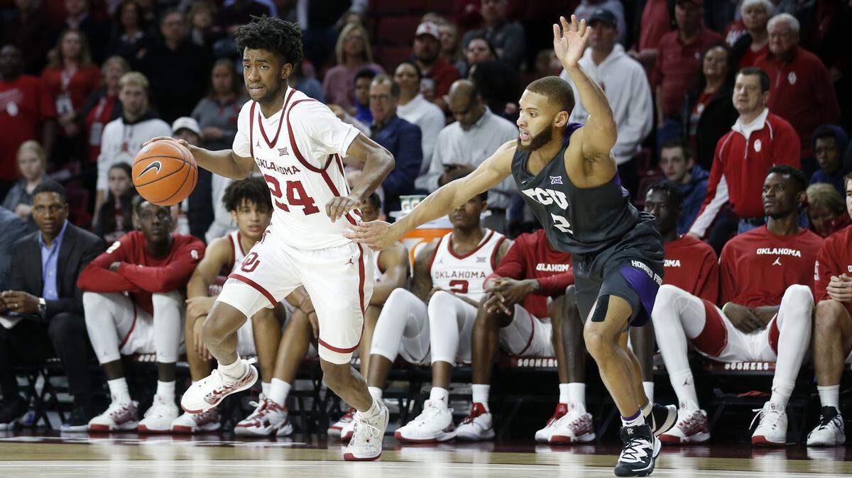 Oklahoma’s Jamal Bieniemy (24) drives the ball away from TCU’s Edric Dennis Jr. (2) during the second half of an NCAA college basketball game in Norman, Okla., Saturday, Jan. 18, 2020. (AP Photo/Garett Fisbeck)