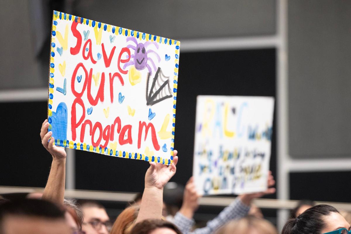 Meeting attendees hold signs in support of their schools and programs that are at risk of being closed by FWISD during a FWISD School Board Meeting at the District Administration Building in Fort Worth on Tuesday, May, 20, 2025.