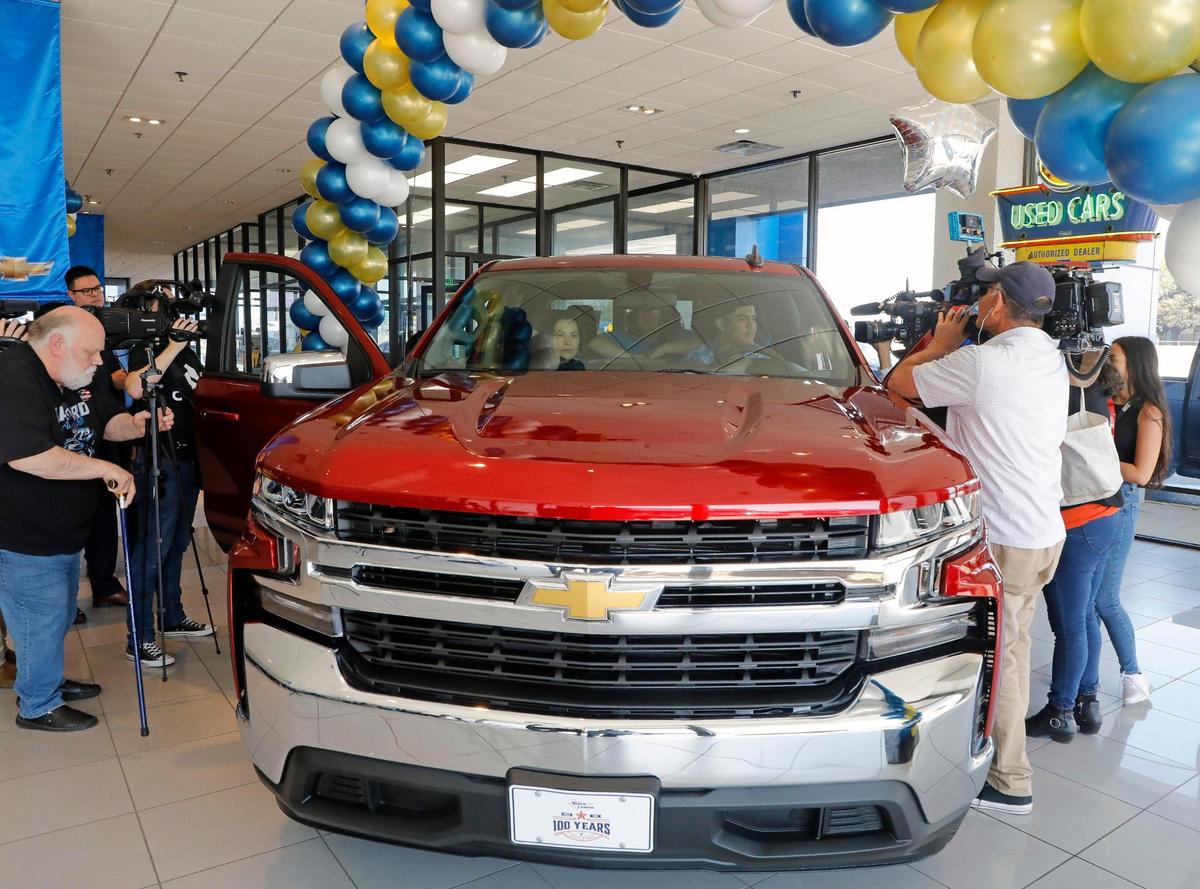 Media surrounds the Silverado to interview Riley Leon, 16, and his mother, Elvia, in the passenger seat at Bruce Lowrie Chevrolet in Fort Worth, Texas, Saturday, March 26, 2022. Leon received a new Chevrolet Silverado after the one he was driving was totaled in a tornado.