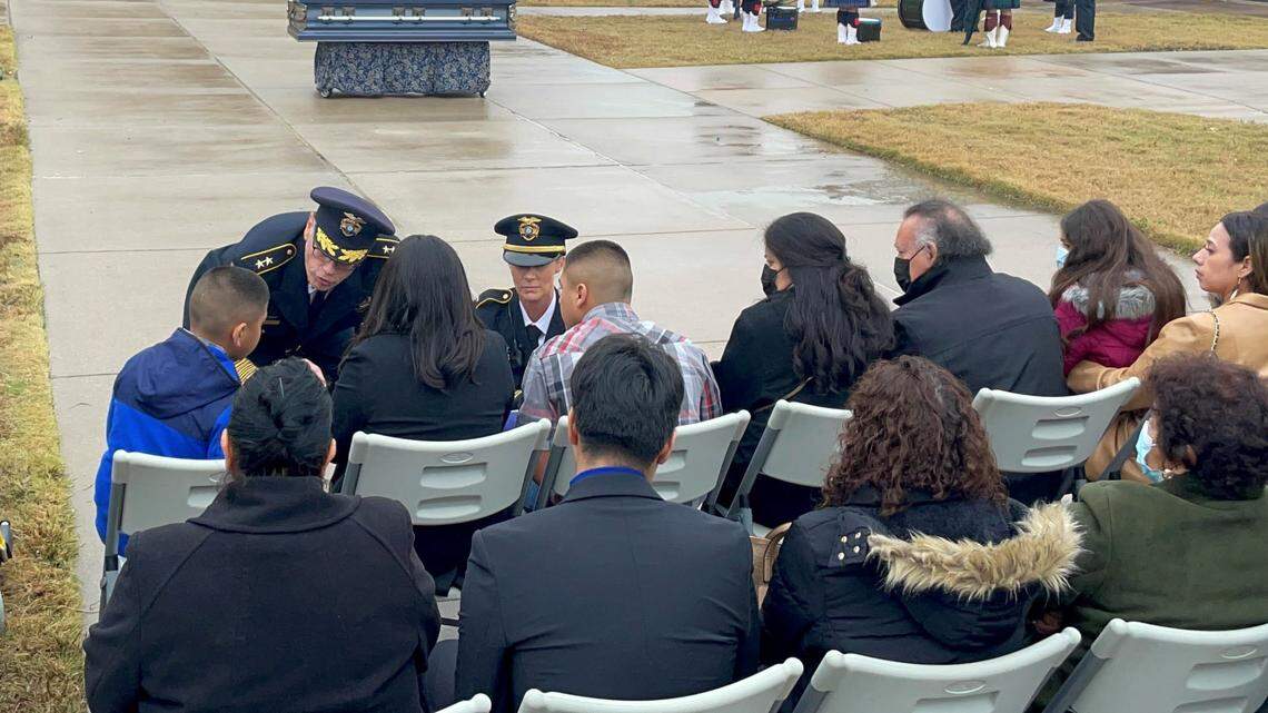 Euless Chief of Police Mike Brown shares whispered words with the sons of Detective Alejandro “Alex” Cervantes during police honors at the detective’s funeral after handing a folded flag to his wife, Priscilla Cervantes.