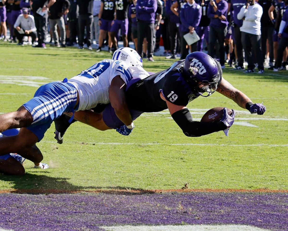 TCU tight end Jared Wiley (19) lunges into the end zone for a touchdown defended by BYU linebacker AJ Vongphachanh (10) during their Big 12 game at Amon G. Carter Stadium on Sasturday.