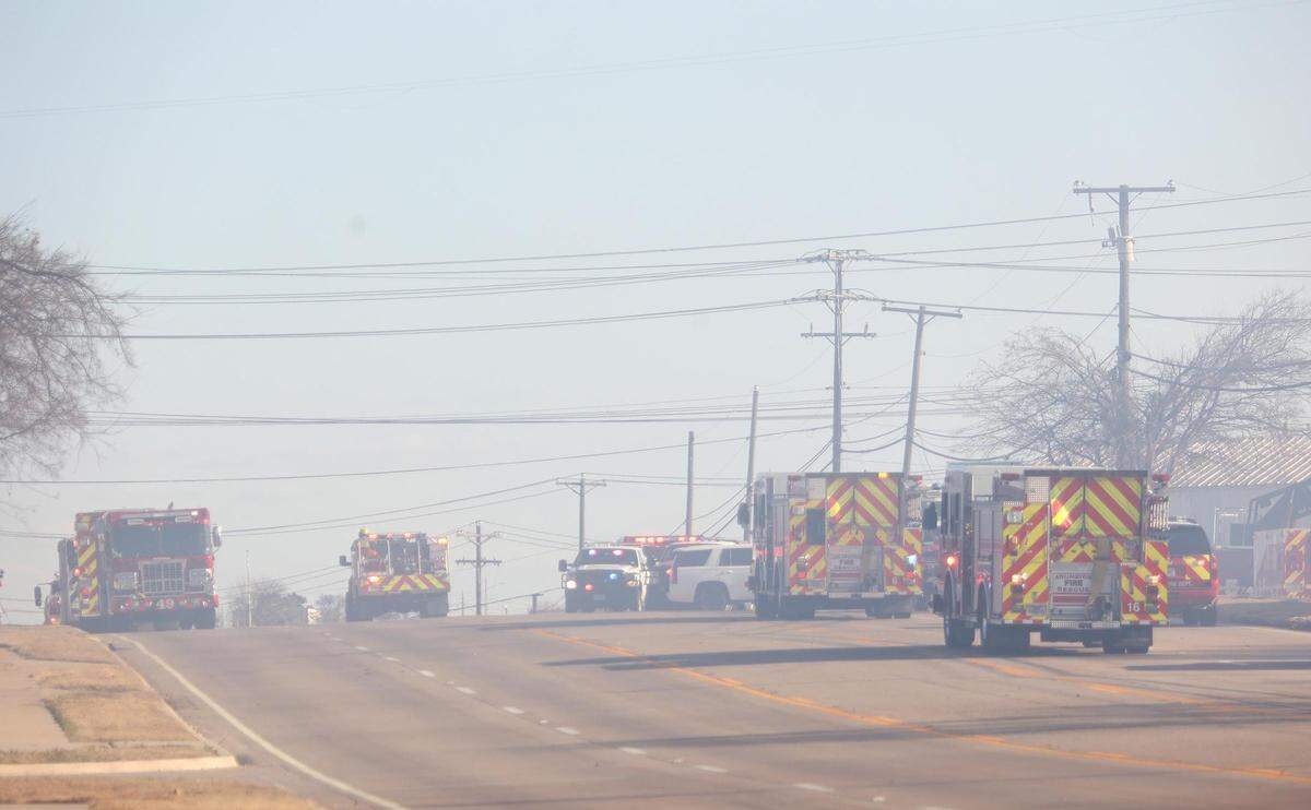 Fire engines line Kennedale Parkway while multiple fire departments work to contain a grass fire in Kennedale on Tuesday, February 15, 2022.